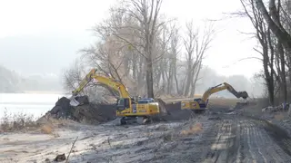 Two excavators in action on the riverbank