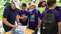 viadonau-Expertin blättern mit Kindern in einem Ordnern mit Fotos