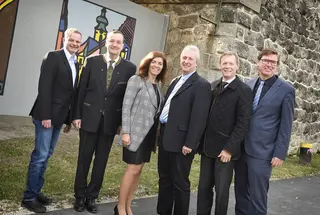 Gruppenbild vor künstlerisch gestalteter Brückenmauer
