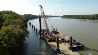 Excavator working on the riverside, building berth
