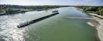 Güterschiff im Vordergrund, Passagierschiff im Hintergrund auf der Donau in Richtung Horizont