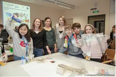 The PlasticFreeDanube Teamm together with children in front of a table with sortet plastic waste