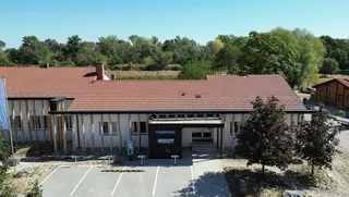 Servicecenter mit neuer Fassade aus Holzstämmen