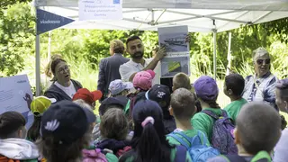 Kinder im Vordergrund, Experte erklärt im Hintergrund