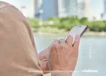 Cover Jahresbericht 2017 - Frau bedient vor Donau ein Mobiltelefon
