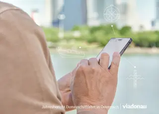 Cover Jahresbericht 2017 - Frau bedient vor Donau ein Mobiltelefon