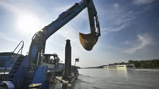 Bagger auf der Donau, Passagierschiff im Hintergrund