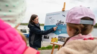 Vermessungsexpertin erklärt anhand Infoposter