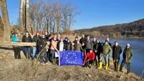 MERLIN Projektpartner mit EU-Flagge am Donauufer