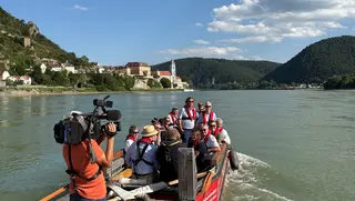 Ausflugsgruppe auf Boot, im Hintergrund Dürenstein.
