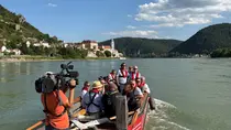 Ausflugsgruppe auf Boot, im Hintergrund Dürenstein.