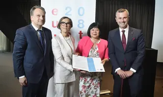 Four people holding the draft paper