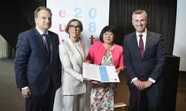 Four people holding the draft paper