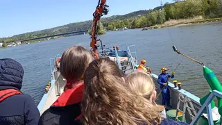 Eine Boje wird mit einem Kran zur Kontrolle aus dem Wasser geholt
