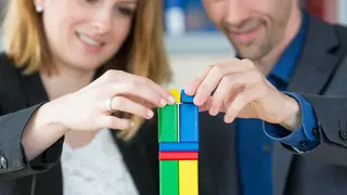 Hände mit Bausteinen