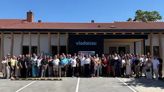 Großes Gruppenfoto vor dem neuen Servicecenter