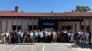 Großes Gruppenfoto vor dem neuen Servicecenter
